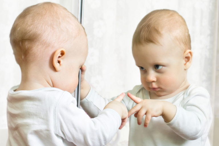 baby looking in mirror Synergetic Play Therapy Institute